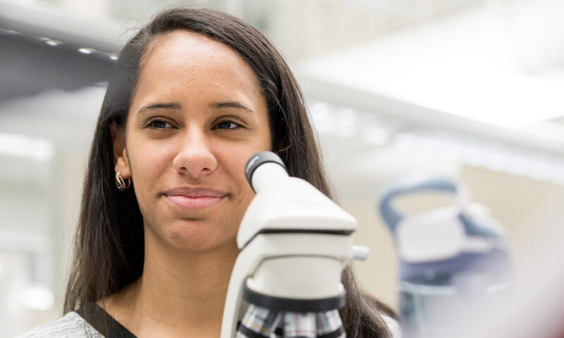 Student using microscope in lab